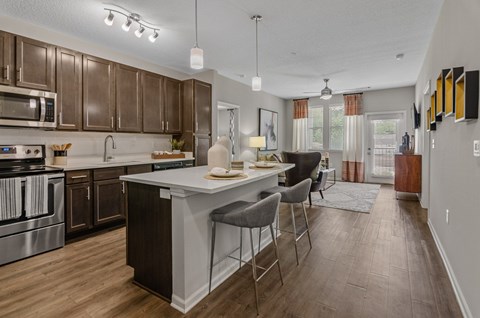 an open kitchen and living room with a large island with chairs